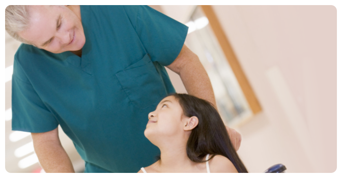 child in a wheelchair with nurse